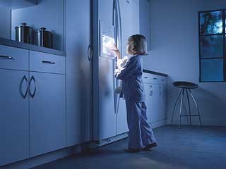 Child opening a refridgerator.